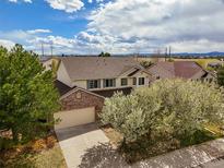 Charming two-story home with a brick facade and a well-manicured front yard and blue skies at 5934 Kingsfield St, Castle Rock, CO 80104