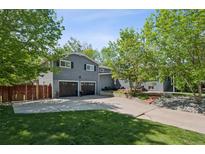 Lovely home with a large driveway, a two-car garage, and mature trees in the front yard at 2865 Newland St, Wheat Ridge, CO 80214