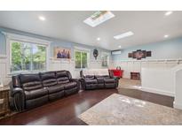 Bright living room featuring hardwood floors, two leather sofas and skylights at 2865 Newland St, Wheat Ridge, CO 80214