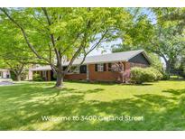 Charming brick home with a well-maintained lawn and mature trees providing shade and curb appeal at 3400 Garland St, Wheat Ridge, CO 80033