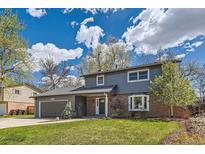 Charming two-story home features a well-manicured lawn, a two-car garage, and mature trees at 4682 Chatham St, Boulder, CO 80301