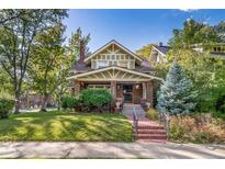 Brick home with mature landscaping and inviting front porch at 2203 Bellaire St, Denver, CO 80207