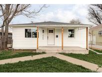 Exterior view of a cozy white home with new porch at 1405 Eaton St, Lakewood, CO 80214