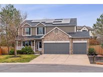 Inviting two-story home featuring a three-car garage, stone accents, solar panels, and well-maintained landscaping at 5370 S Flanders Way, Centennial, CO 80015