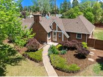 Beautiful brick home featuring a manicured front yard and charming stone walkway leading to the front door at 2500 Locust St, Denver, CO 80207