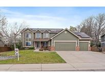 Charming two-story home with a three-car garage, solar panels, and well-maintained lawn at 9251 Sand Hill Trl, Highlands Ranch, CO 80126