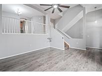 An open living room features hard surface floors, a ceiling fan and a staircase at 1473 Red Cliff Way, Castle Rock, CO 80109