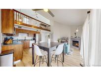 Open-concept living space featuring a modern kitchen, dining area, and cozy living room with a fireplace at 12368 W Nevada Pl # 303, Lakewood, CO 80228