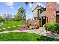 Charming two-story home with beautiful landscaping, colorful flowers, and lush green lawn at 11771 Elk Head Range Rd, Littleton, CO 80127