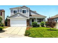 Charming two-story home featuring a well-manicured lawn and a two-car garage with beautiful stone accents at 5613 S Sicily Cir, Aurora, CO 80015