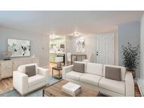 Bright living room featuring modern furnishings, including a white sofa and stylish decor, with a kitchen and dining space visible at 336 N Grant St # 412, Denver, CO 80203