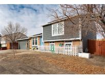 House exterior with gray siding, blue door, and a small yard at 831 Centennial Dr, Bennett, CO 80102
