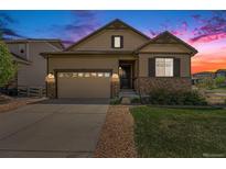 Charming single-Gathering home with a well-manicured lawn, stone accents, and a two-car garage under a colorful sky at 3480 Mount Powell Dr, Broomfield, CO 80023