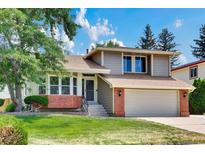 Charming two-story home featuring a well-manicured lawn, brick accents, and an attached two-car garage at 3973 S Joplin Way, Aurora, CO 80013