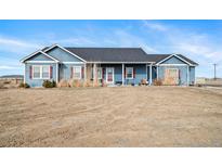 Charming single-story blue home with a well-maintained front yard and inviting curb appeal at 253 E 8Th Ave, Byers, CO 80103