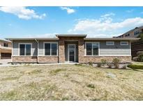 Charming single-story home with stone accents and a well-maintained front yard under a bright, partly cloudy sky at 12278 Stone Timber Ct, Parker, CO 80134