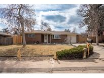 Charming red brick ranch-style home with manicured lawn and mature trees at 9390 W Alabama Dr, Lakewood, CO 80232