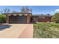 Charming brick home with attached garage and well-manicured lawn on a sunny day at 5975 S Milwaukee Way, Centennial, CO 80121