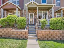 Charming townhome entrance with stone accents, a welcoming front porch, and tidy landscaping at 13638 Garfield St # C, Thornton, CO 80602