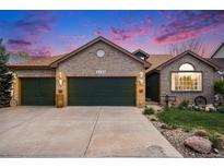 Charming brick home featuring a three-car garage and a well-maintained front yard with a concrete driveway at 2190 Coyote Creek Dr, Fort Lupton, CO 80621