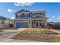 Charming two-story home with blue siding, a well-manicured lawn, and an inviting front porch at 1489 N Monument Dr, Castle Rock, CO 80104