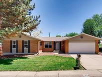 Charming single-story brick home featuring a well-maintained lawn, mature trees, and attached two-car garage at 2964 S Akron St, Denver, CO 80231