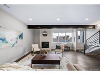 Bright living room with a fireplace, large window, and modern furnishings at 1810 Julian St # 105, Denver, CO 80204