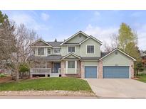 Beautiful home boasts fresh green paint, a lovely porch, and vibrant curb appeal at 7307 Pine Forest Ln, Parker, CO 80134