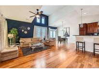 Bright living room features hardwood floors, a ceiling fan, and a stylish accent wall at 6742 S Winnipeg Cir # 105, Aurora, CO 80016