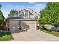 Inviting home with a brick-accented facade, two-car garage, and well-maintained lawn at 15597 E Dorado Ave, Centennial, CO 80015