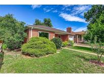 Charming brick home featuring a well-maintained lawn and mature landscaping at 1541 Poplar St, Denver, CO 80220