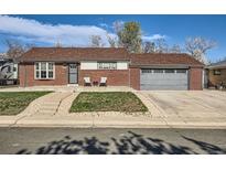Charming brick home featuring a well-manicured lawn and an inviting two-car garage at 7120 Galapago St, Denver, CO 80221