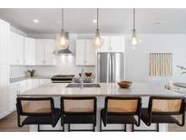Bright kitchen features an island with bar seating and modern stainless steel appliances at 2952 S Delaware St, Englewood, CO 80110