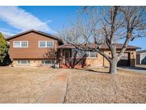 Charming split-level home with a wood and brick exterior and inviting front porch at 860 S 7Th Ave, Brighton, CO 80601