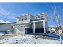 Two-story house with gray siding, stone accents, and a two-car garage at 3734 Makley Cir, Castle Rock, CO 80104