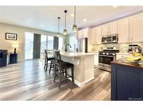 Bright, open kitchen featuring stainless steel appliances, white cabinets, and a quartz countertop island with bar seating at 3734 Makley Cir, Castle Rock, CO 80104