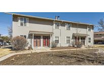 A daytime exterior view of a multi-Gathering home with light colored siding and red doors at 1922 S Oswego Way, Aurora, CO 80014