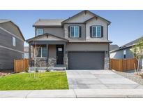 Two-story house with gray siding, stone accents, and a two-car garage at 27500 E Cedar Pl, Aurora, CO 80018