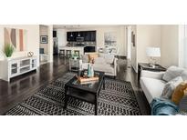 Open concept living space with dark hardwood floors, black accents and modern furnishings at 10465 Evansville Cir, Parker, CO 80134