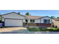 Charming single-story home with a brick accent, a two car garage, and a well-maintained lawn at 8721 W 86Th Ave, Arvada, CO 80005