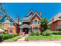 Charming brick home featuring detailed gables, arched windows, and a well-maintained front yard with mature landscaping at 931 E 17Th Ave, Denver, CO 80218