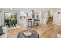 Open-concept living space with hardwood floors, a modern kitchen, and bright natural light at 9345 W Iowa Pl, Lakewood, CO 80232