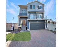 Modern two-story home with blue siding, a front-facing garage, and a small front lawn at 17908 E 54Th Ave, Denver, CO 80249