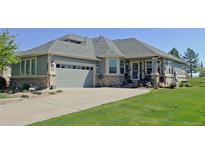 Charming home featuring a spacious driveway, a well-manicured lawn, and a welcoming two-car garage at 7824 S Zante Ct, Aurora, CO 80016