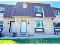 Inviting townhome exterior with brick facade, front door, windows, and well-maintained landscaping at 5677 S Lowell Blvd, Littleton, CO 80123