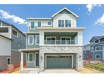 Inviting two-story home featuring stylish gray siding, brick accents, and a covered front porch at 8376 Cokedale Dr, Littleton, CO 80125