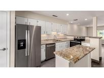 Updated kitchen features stainless steel appliances, granite countertops, and white cabinets at 2301 E Fremont Ave # W08, Centennial, CO 80122