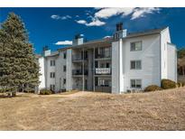 Multi-Gathering building featuring balconies, light grey wood siding, and lush landscaping at 13095 W Cedar Dr # 107, Lakewood, CO 80228