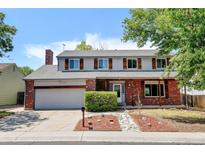 Charming two-story home with a brick facade, shutters, and a well-maintained front yard at 1487 S Zeno Way, Aurora, CO 80017