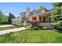 Stunning two-story home featuring a manicured lawn, a three-car garage, and a covered porch entrance at 4800 E Cedar Ave, Denver, CO 80246